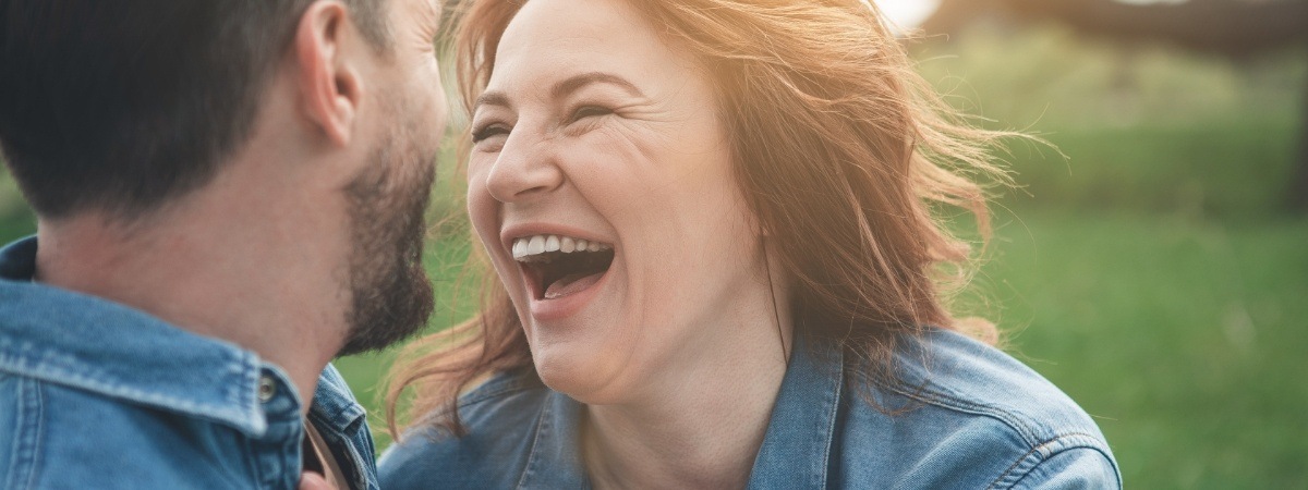 Man and woman smiling together after full mouth reconstruction