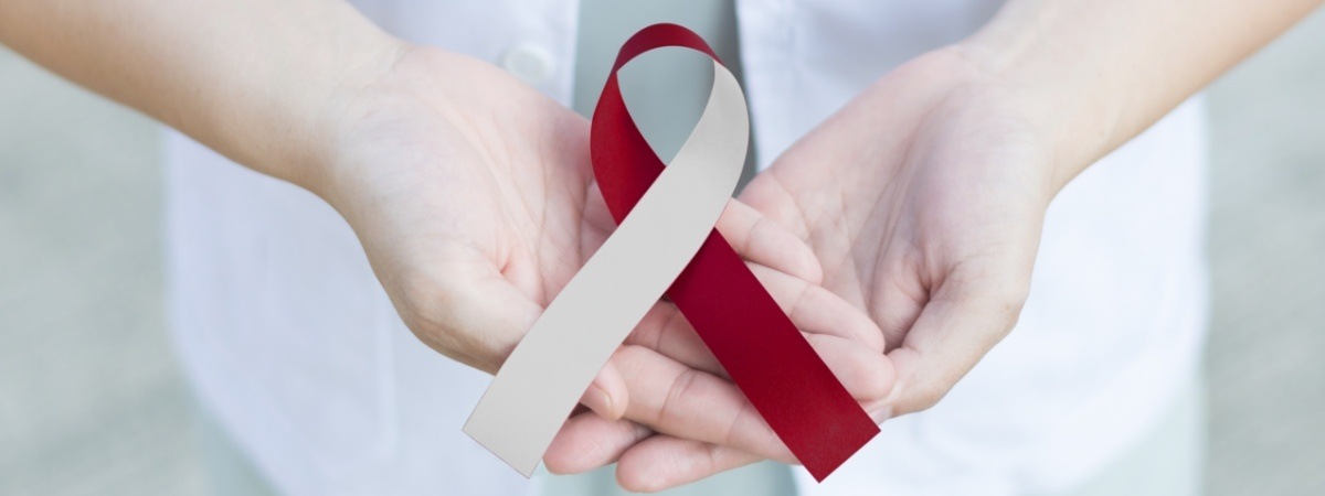 Dentist holding oral cancer awareness ribbon as a reminder to get screenings