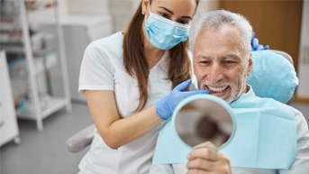 man smiling while looking in mirror