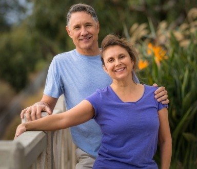 Smiling man and woman enjoying the benefits of same day dental crowns