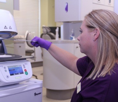 Dental team member sanitizing treatment tools after dental checkup