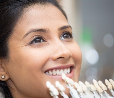 Woman's smile compared to porcelain veneers color options