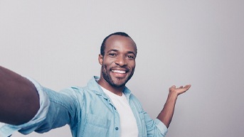 man taking a happy selfie after learning options for making cosmetic dentistry affordable