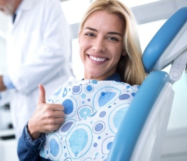 Woman smiling after dental crown and fixed bridge restoration