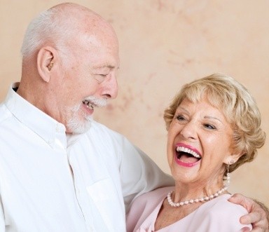 Older couple with dentures laughing together