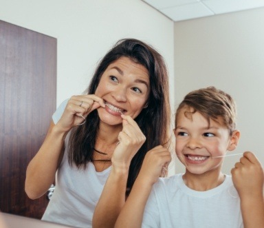 Mother and child flossing to prevent dental emergencies