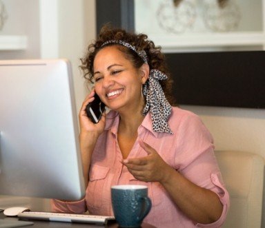 Dental team member smiling and answering phone