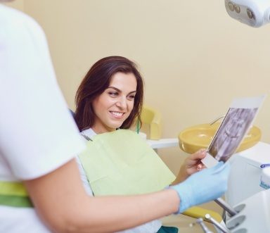 Woman and dentist discussing tooth extraction healing and recovery