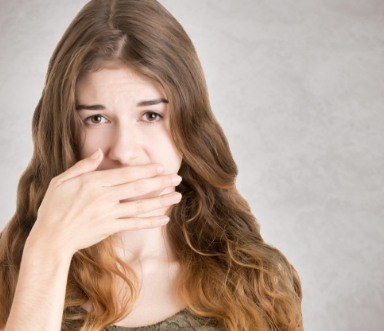 Fearful patient covering mouth before tooth extractions