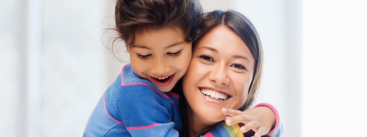 Mother hugging child after family dentistry visit