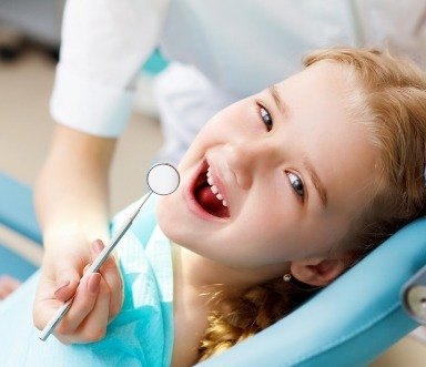 Child smiling during a visit to a family dentist