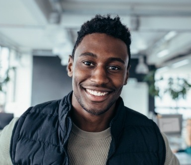 Young man sharing flawlessly restorated healthy smile after tooth colored fillings