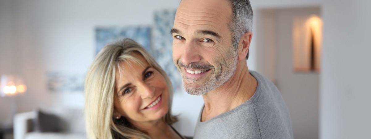 Man and woman with dental implant supported dentures smiling