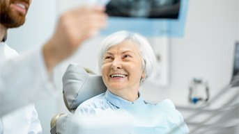 woman smiling at dentist after getting new teeth