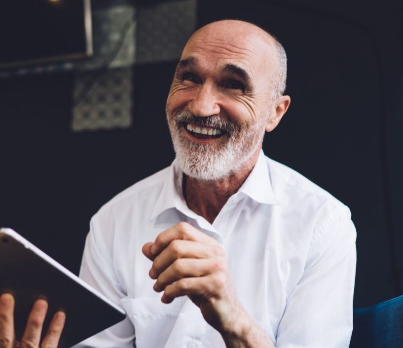 Smiling senior man holding a tablet