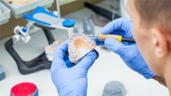 Lab technician carving dentures