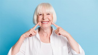 Woman pointing to her smile