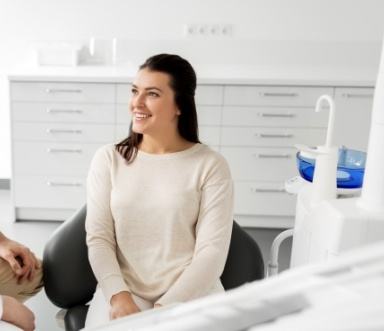 Woman smiling at dentist during smile makeover process