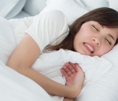 Woman grinding teeth during sleep