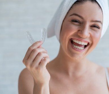 Woman smiling and holding her nightguard