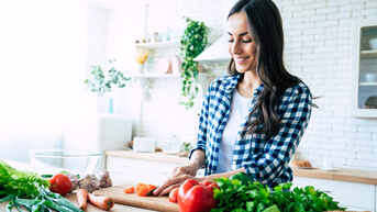 woman cutting vegetables in kitchen