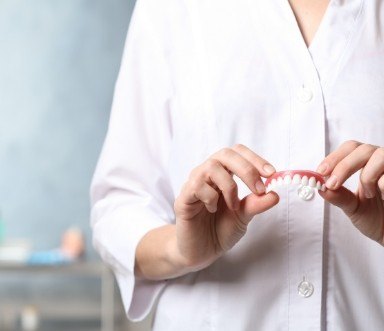 Dentist holding a set of dentures