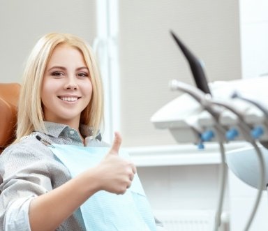Woman giving thumbs up after comfortable tooth extractions