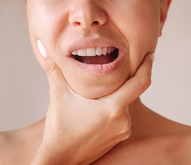 a patient holding her jaw in pain