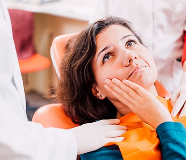 a patient holding her jaw in pain