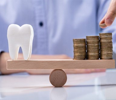Tooth being balanced against a pile of coins