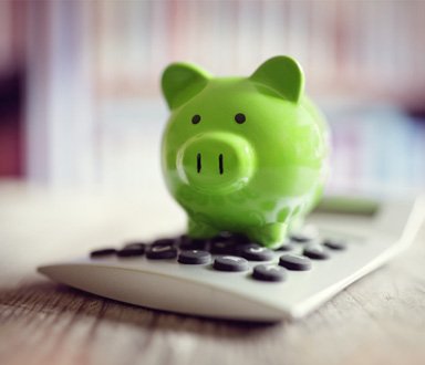 Piggy bank sitting on a calculator