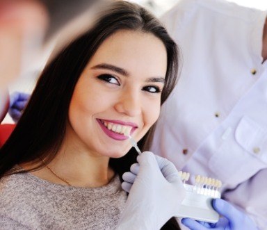 Woman's smile compared to porcelain veneer shade chart