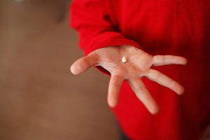 Extracted tooth in outstretched hand of Burlington emergency dentist