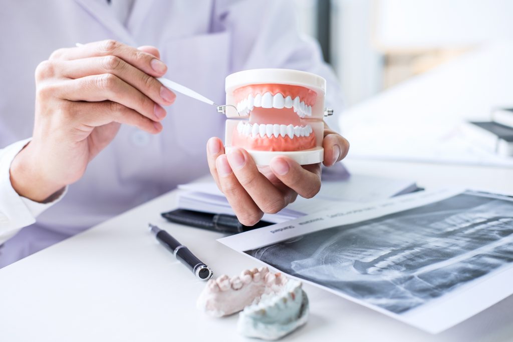 dentist holding set of dentures