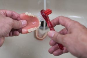 a person cleaning their denture