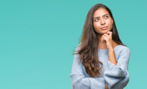 young woman thinking about dental insurance 