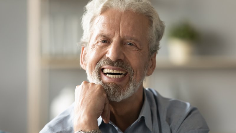 Older man smiling after getting his dentures relined