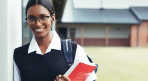 teen in school hallway holding books