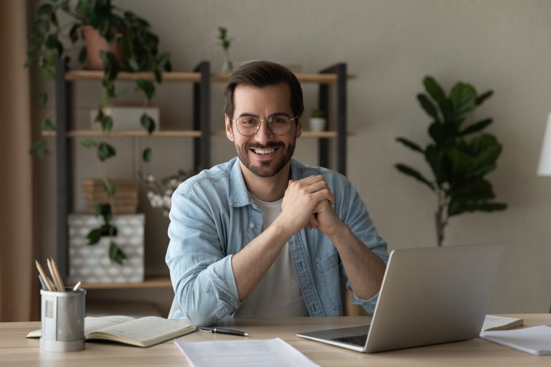 Man sitting at desk with a confident smile